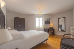 a bedroom with a large white bed and a window at Hotel De L'Europe in Toul +69 photos