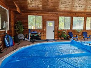a large swimming pool in a room with a house at Ellison Funny Farm in Barrière