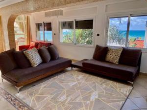 a living room with two couches and a view of the ocean at villa assalam Tanger in Tangier