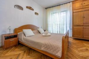 a bedroom with a bed with a dresser and a window at House Igor in Ledenice +21 photos