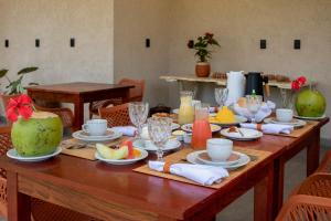 a wooden table with plates of food on it at Kokoye Boutique Hotel in Pôrto de Pedras