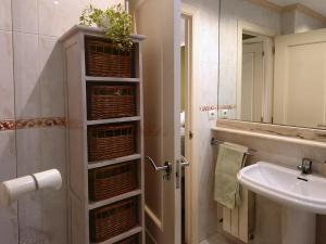 a bathroom with a sink and a shower with baskets at Apartamento, zona residencia con piscina, cerca de las playas en Santander in Santander +36 photos
