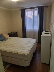 a bedroom with a large bed and a window at Departamento duplex excelente condominio in Chorrillos