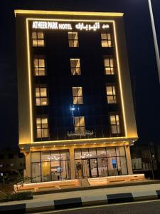 a building with a sign on top of it at night at فندق أثير بارك in Jazan