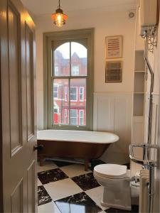 a bathroom with a tub and a toilet and a window at The Saltburn Townhouse in Saltburn-by-the-Sea