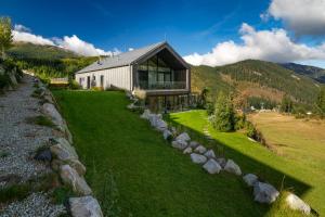 een huis op een heuvel met een stenen muur bij Apartments Severka - Jasná in Demanovska Dolina