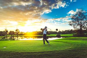 a man swinging a golf club on a golf course at Copperheads 14th Hole Tee Box View in Lake Shore Estates
