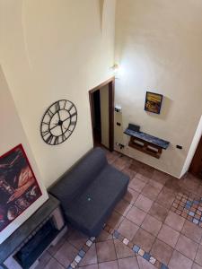 a room with a couch and a clock on the wall at Living Adua Centro in Tortona