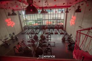 Un gimnasio con filas de máquinas de correr y luces rojas. en Bloum at 22, City Views and Wonderland Vibes!, en Hatillo