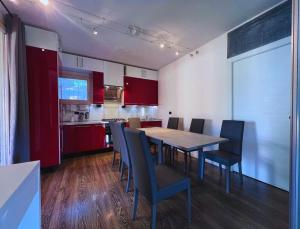 a kitchen with a table and chairs and red cabinets at B2In Suite & Office in Capriate San Gervasio