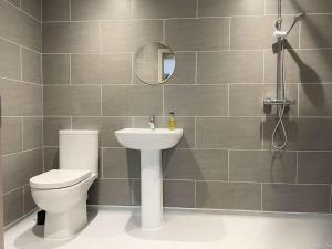 un bagno con un water, un lavandino e uno specchio di SALTKETTLE - Blakeney a Blakeney Altre 25 foto