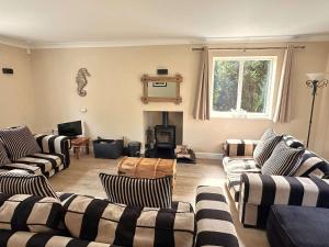 un soggiorno con divani a righe e camino di SALTKETTLE - Blakeney a Blakeney