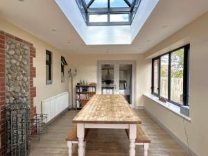 un lungo tavolo in una stanza con un lucernario di SALTKETTLE - Blakeney a Blakeney