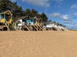 une rangée de maisons colorées sur une plage dans l'établissement COSY COTTAGE - Wells-next-the-Sea, à Wells-next-the-Sea