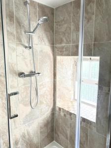ein Badezimmer mit Dusche mit Glastür in der Unterkunft Havelock Cottages in Oundle