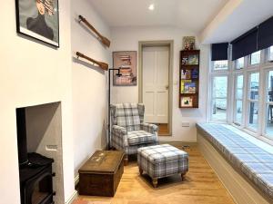 ein Wohnzimmer mit einem Stuhl und einem Kamin in der Unterkunft IVY COTTAGE - Walsingham in Little Walsingham + 12 Fotos