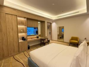 a bedroom with a bed and a desk and a television at فندق أثير بارك in Jazan +36 photos