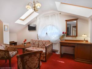 a living room with a couch and a desk and a mirror at Dworek Vesaria in Lublin