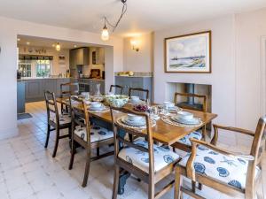 a kitchen and dining room with a wooden table and chairs at FORGETMENOT COTTAGE FOR TWO - Wells-next-the-Sea in Wells next the Sea
