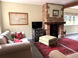 a living room with a couch and a fireplace at Plum Tree Cottage, Burnham Market By Together Travel in Burnham Market