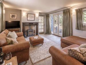 a living room with brown furniture and a fireplace at FORGETMENOT COTTAGE - Wells-next-the-Sea in Wells next the Sea