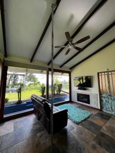 a living room with a ceiling fan and a couch at Casa Bali in San Francisco de Palmera
