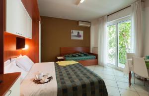 um quarto de hotel com uma cama e uma janela em Riviera Residence em Rimini