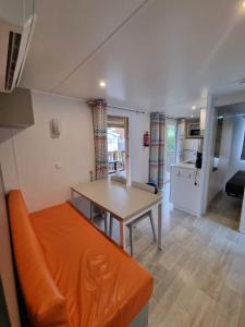 Una sala de estar con un sofá naranja y una mesa. en MH300 le clarys camping 5 étoiles, en Saint-Jean-de-Monts