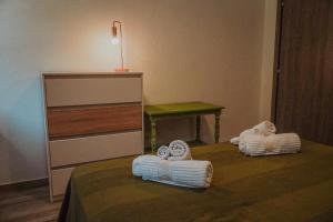 a room with a bed with folded towels on it at Bridge View Cottage in Podhokhórion