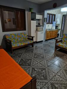 a living room with two couches and a kitchen at Apartamento térreo Torres centro in Torres