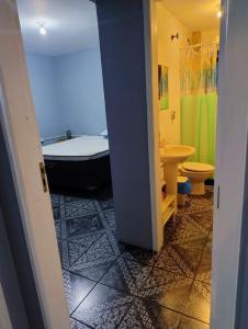 a bathroom with a tub and a toilet and a sink at Apartamento térreo Torres centro in Torres +4 photos