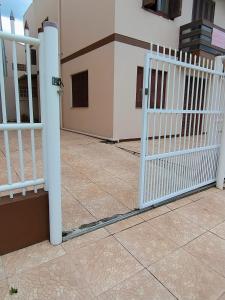 a white gate in front of a house at Apartamento térreo Torres centro in Torres