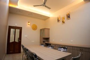a room with a table with chairs and a ceiling fan at Satguru Villa in Varanasi