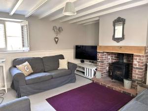 un soggiorno con divano e camino di WELL COTTAGE - Salthouse a Salthouse