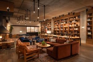 una sala de estar con sofás, mesas y estanterías en The Junto Hotel, en Columbus