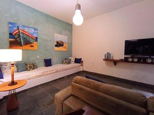 un salon avec un canapé et une télévision à écran plat dans l'établissement Modern loft con vista mar, à Búzios