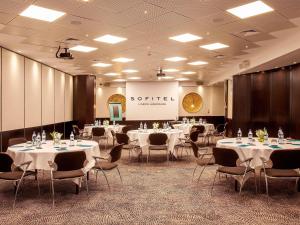 a conference room with tables and chairs and a screen at Sofitel Lisbon Liberdade in Lisbon