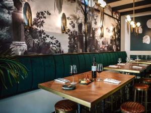 a dining room with two tables and wine glasses at Sofitel Lisbon Liberdade in Lisbon