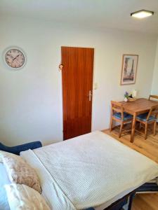 a bedroom with a bed and a table and a clock at Family Apartment Tauchen 8 in Mönichkirchen +2 photos