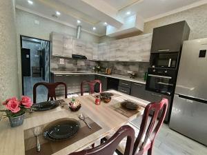 a kitchen with a table with chairs and a refrigerator at Apartments in the center in Dushanbe