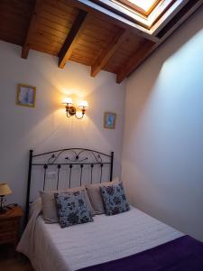 a bedroom with a bed with white sheets and a skylight at Apartamentos Rurales Llagumelon in Villahormes