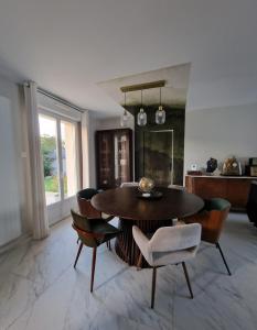 a dining room with a table and chairs at Maison joliment décorée dans un quartier calme in Savigné-lʼÉvêque