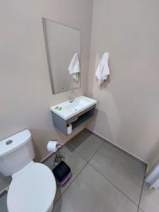 a bathroom with a white toilet and a sink at Studio Cataratas com garagem e ar condicionado in Foz do Iguaçu +9 photos