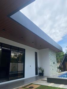 a white house with a blue roof and a swimming pool at Grand Cabins in Panglao Island