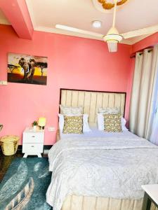 a bedroom with pink walls and a large bed at The central Heartbeat Haven Intercity 1 in Dar es Salaam