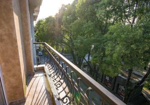 a balcony with a fence and trees on a street at City Apartments La Casa in Varna City