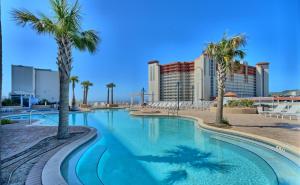 una piscina con palmeras y edificios en Laketown Wharf 114, en Panama City Beach