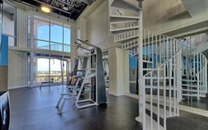 un gimnasio con cintas de correr y escaleras en un edificio en Laketown Wharf 114, en Panama City Beach