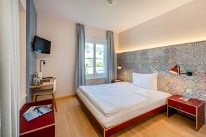 a hotel room with a bed and a window at Bären Self Check-in Hotel in Solothurn +52 photos