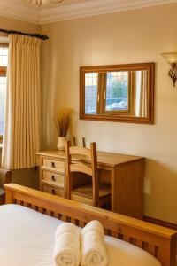 a bedroom with a desk and a table with a chair at Elegant Vintage Stay Near Airport & NEC in Birmingham